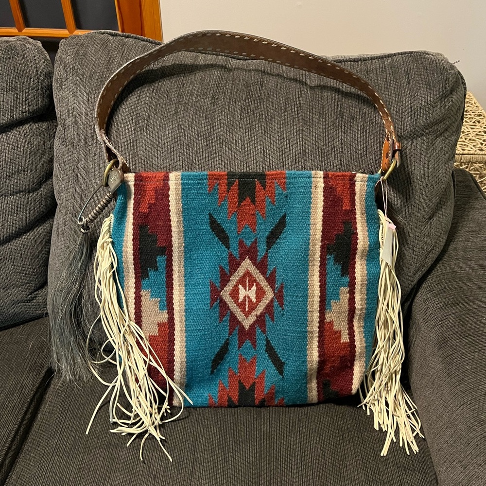 Women’s western shoulder bag with vintage belt strap.